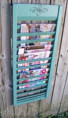 a magazine rack mounted to the side of a wooden fence