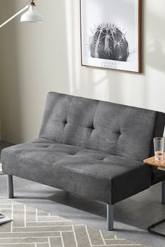 a living room with a futon couch and coffee table