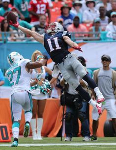 a football player jumping into the air to catch a ball