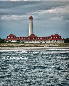 a red and white light house sitting on top of a beach