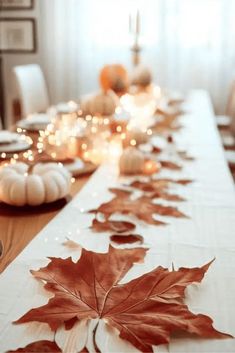 the table is set with candles and leaves