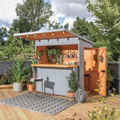 an outdoor bar with potted plants on the outside and wooden flooring in front