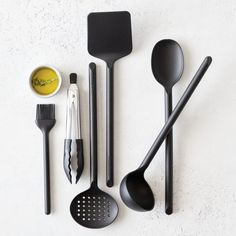 various kitchen utensils are arranged on a white surface