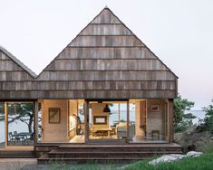 two wooden buildings with glass doors on the front and back sides, one has an open patio