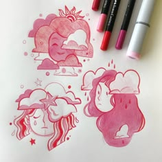 some pink colored markers are on a sheet of paper and there is a drawing of two girls