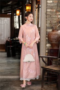 This exquisite dress is a contemporary adaptation of the traditional qipao (cheongsam), showcasing a loose fit that ensures comfort and grace. The dress is crafted from a light, elegant pink fabric, adorned with delicate floral embroidery, making it a perfect choice for both casual and formal events. Key features include: Intricate Floral Embroidery: The dress is embellished with beautiful floral embroidery, adding a touch of elegance and femininity. Classic Mandarin Collar: The mandarin collar Traditional Qipao, Qipao Cheongsam, Qipao Dress, Embroidery Gifts, Wedding Essentials, Cheongsam, Pink Fabric, Home Wedding, Mandarin Collar