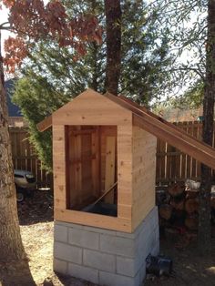 a small wooden outhouse sitting next to a tree