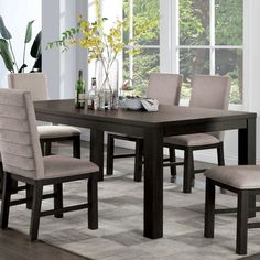 a dining room table and chairs in front of a window