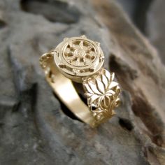 Dharma Ring Gold - Includes the Dharma Wheel and Lotus Flower symbols. Symbolizes the way out of the endless cycle of life and death and suffering - the Samsara    On top of the ring there is the Dharma Wheel Symbol.  The circle, the round shape of the wheel, represents the perfection of the Dharma, the Buddha's teaching.  The rim of the wheel represents meditative concentration and mindfulness, which hold practice together. Flower Symbols, Flower Symbol, Dharma Wheel, Buddha Teachings, Cycle Of Life, The Endless, Ring Gold, Lotus Flower, Shopping Cart