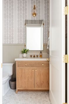 a bathroom with a sink, mirror and toilet in it's doorway way that leads to a bathtub