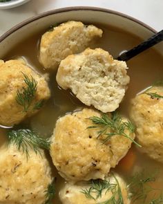 a bowl filled with soup and dumplings on top of a table