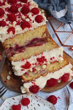 a cake with white frosting and raspberries on it