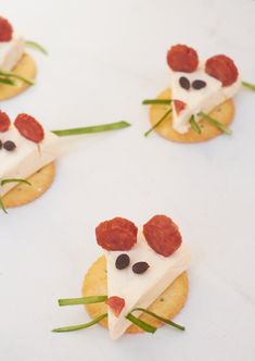 small crackers with cheese and toppings shaped like mice on top of each other