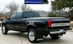 a black pickup truck parked in a driveway