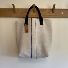 "New style Shopper - a really practical sized bag with a roomy interior, great for all your beach essentials or simply for those days when you need that little bit extra room. Made from a durable vintage hop sack with a double blue vertical stripe. Lined in a Jenney Wren hand block printed vintage linen, with an interior slip pocket. There is a magnetic closure and sturdy navy blue-coloured handles and our exclusive laser-etched hardwood Jenney Wren label on the inside pocket Sizing: This bag measures approximately 18.5\" (47cm) width x 17.7\" (45cm) deep. The handles are approximately 6\" (15cm) above the top of the bag." Practical Everyday Bucket Bag, Eco-friendly Travel Bags With Rolled Handles, Everyday Practical Bucket Bag, Everyday Large Bags With Rolled Handles, Casual Bag With Natural Color And Canvas Lining, Casual Bag With Canvas Lining In Natural Color, Casual Bags With Canvas Lining In Natural Color, Casual Canvas Bag With Rolled Handles For Travel, Large Natural Canvas Bag For Daily Use