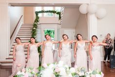 a group of women standing next to each other in front of a table with flowers