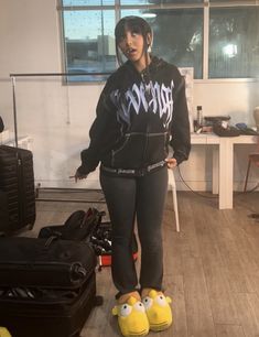 a woman in black jacket standing next to luggage