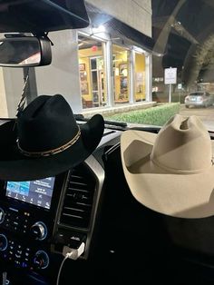 two hats are sitting on the dashboard of a car