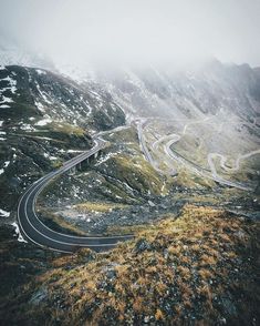 an aerial view of a winding road in the mountains