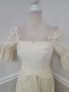 a white dress with ruffles on the shoulders