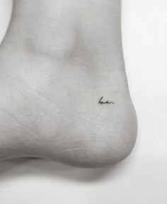 a small tattoo on the foot of a person's left leg that reads love