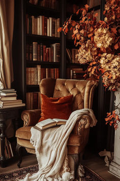 a chair with a blanket on it in front of a book shelf filled with books