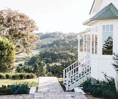 a white house sitting on top of a lush green hillside