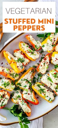 stuffed mini peppers with cheese and herbs on a white platter next to some bread