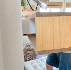 a man holding up a wooden box in the air above his head on a bed