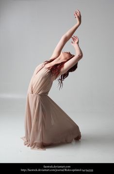 a woman in a long dress is doing an acrobatic pose