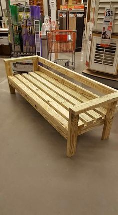 a wooden bench sitting inside of a store next to other items in the background,