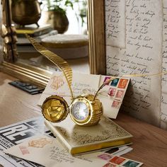 a golden ring sitting on top of a book next to a mirror