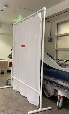 a boat is being worked on in a garage with white curtains hanging from the ceiling