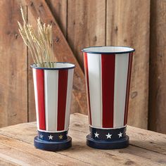 two red, white and blue vases sitting on top of a wooden table next to each other