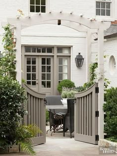 a white house with an outdoor dining table and potted plants on the front porch