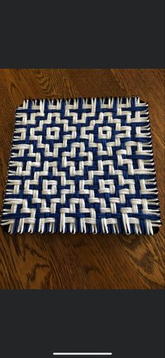 a blue and white placemat sitting on top of a wooden table next to a wood floor