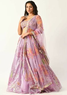 Become the talk of the town with this light weighted printed lehenga that has lily motifs all over highlighted with hand embroidery. The sleeveless blouse has a modern silhouette with embroidered patchwork as an ornamentation. Designer Purple Lehenga With Motifs, Lavender Choli With Sheer Dupatta, Lavender Organza Sets With Dupatta, Purple Anarkali Lehenga With Floral Embroidery, Festive Lavender Embroidered Lehenga, Festive Embroidered Lavender Lehenga, Purple Chanderi Lehenga With Motifs, Bollywood Lavender Choli With Intricate Embroidery, Bollywood Style Lavender Choli With Intricate Embroidery