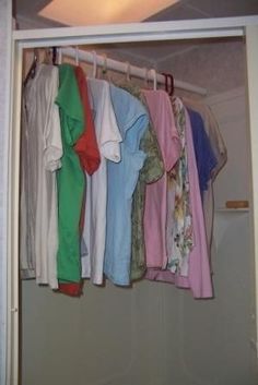 an open closet with clothes hanging in it