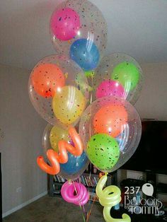 a bunch of balloons that are on top of each other in the middle of a room