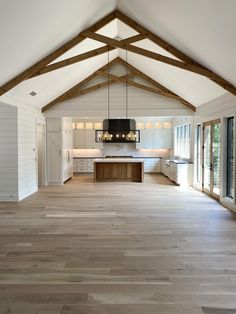 an open floor plan with wood floors and white walls, large windows on both sides