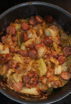 a pan filled with meat and vegetables on top of a stove