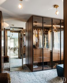 a walk in closet with mirrored doors and clothes hanging on hangers next to it