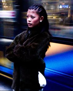 a woman standing in front of a blue train