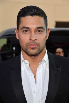 a close up of a person wearing a suit and white shirt with a black blazer