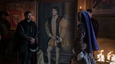 several people standing in front of a painting with a man dressed up as a king