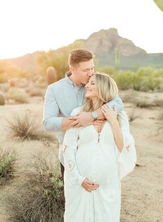 a man and woman embracing each other in the desert