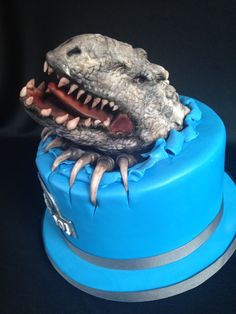 there is a cake that looks like a dinosaur's head on top of it