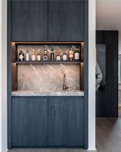 a kitchen with black cabinets and marble counter tops