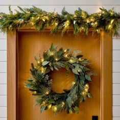 a wooden door with a wreath and lights on it