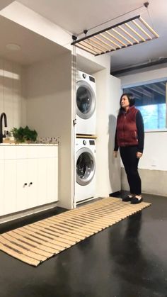 a woman standing in front of a washing machine